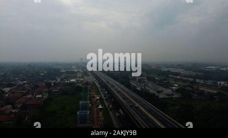 BEKASI, WESTJAVA, INDONESIA : 10 gennaio 2020 :antenna fuco vista autostrada multilevel junction road con vetture in movimento dopo piovosa. Le vetture sono sfocate Foto Stock