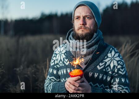 Un viaggiatore solitario che festeggia il suo compleanno in natura, egli tiene nelle sue mani una torta e un giganti in Bengali Foto Stock