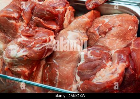 Selezione di differenti tipi di tagli di carne fresca sul display in una macelleria in una vetrina refrigerata. Foto Stock