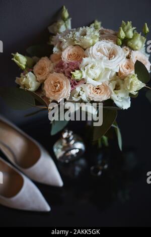 Bouquet di rose fresche, peonie, eucalipto fiori in rosa pastello e colori crema e altri accessori per la sposa. Gli anelli di nozze nuziale, Foto Stock