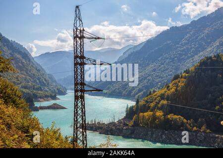 Tensione alta torre in montagne del Caucaso. L'energia idroelettrica, linea di trasmissione pilone sul background del serbatoio di Enguri stazione idroelettrica (Enguri H Foto Stock