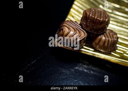 Vari dolci di pasticceria con cioccolatini e praline. Cioccolatini fatti a mano. Realistica insieme al cioccolato, deliziosi dessert pattern. Foto Stock