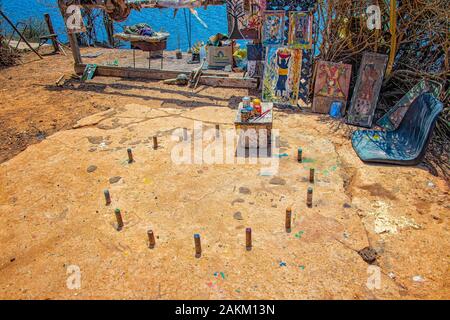 Isola di Goree, Senegal- 22 aprile 2019: belle immagini di legno con tipici colorati disegni senegalesi. Vi sono colori preparati per un artista locale Foto Stock