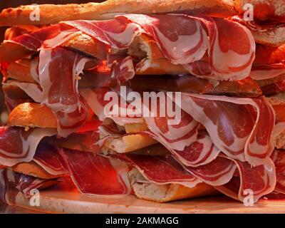 Pila di Pintxos con succulenti prosciutto spagnolo (Jamon Iberica) in pane bianco-sandwich rotolo sul display in un bar di Pamplona, Spagna Foto Stock