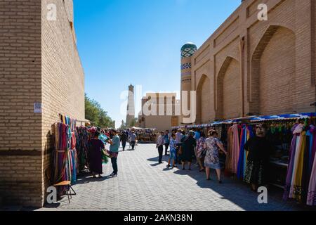 Khiva, Uzbekistan - agosto 2018: Vista della città vecchia di Khiva con visitatori e commercianti. Il centro storico di Khiva è un sito patrimonio dell'umanità dell'UNESCO Foto Stock
