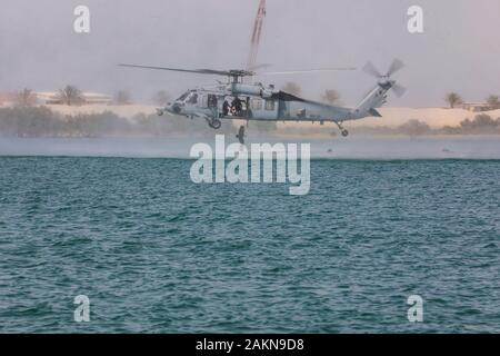 Un soldato con la quinta delle forze speciali Gruppo (Airborne) salta fuori da un U.S. Navy MH-60S Seahawk in acqua durante la formazione Helocast. Helocasting è una tecnica di volo utilizzato da forze per le operazioni speciali per inserire un distacco operativo alfa in una zona militare delle operazioni tramite l'acqua. (U.S. Foto dell'esercito da Staff Sgt. Justin Moeller, quinto SFG(A) Affari pubblici) Foto Stock