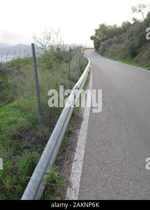 Recinto di filo e crash barriera lungo la strada di campagna nella rurale Andalusia Foto Stock