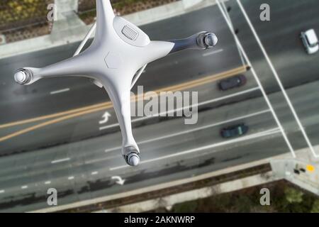 Aerei senza pilota Quadcopter sistema Drone in aria su strada con le automobili. Foto Stock