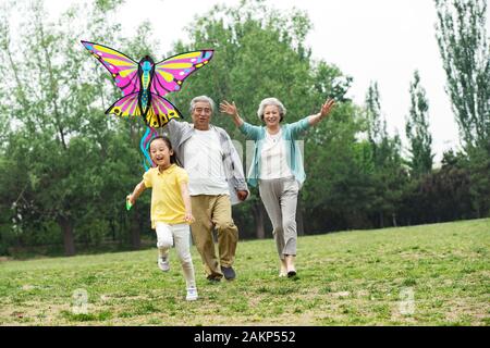 Coppie di anziani con un nipote è volare un aquilone nel parco Foto Stock