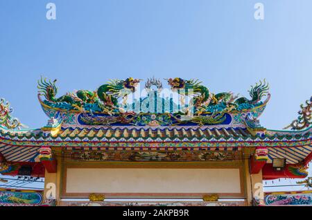 L'ingresso ad arco del santuario cinese è decorato con la statua del drago Foto Stock