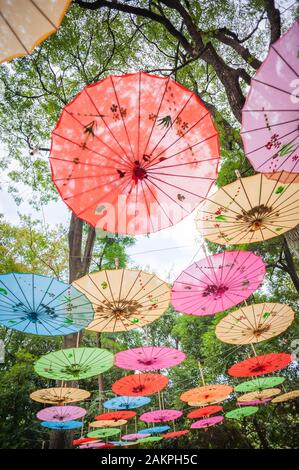 Cinese tradizionale ombrelloni multicolori impiccati sugli alberi a basso angolo di visione in Guilin, provincia di Guangxi, Cina Foto Stock