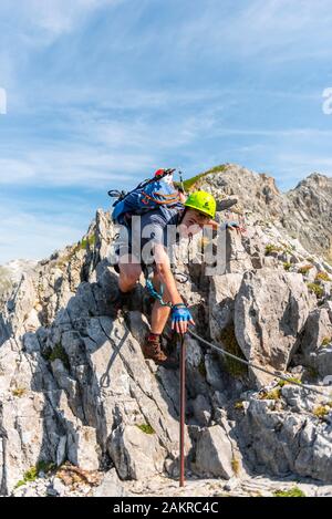 Alpinista, giovane arrampicate su roccia, alpinista su un fissato via ferrata, Mittenwald via ferrata, montagne Karwendel, Mittenwald, Germania Foto Stock