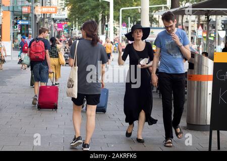 Vienna, AUSTRIA - 05 settembre 2019: Affollate strade autunnali nel centro della città. Donna di mezza età in abito nero stretto lungo e un cappello a testa larga con un Foto Stock