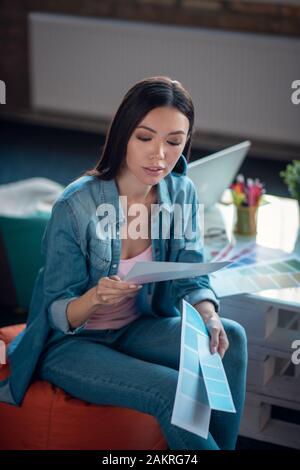 Grave donna creativa concentrandosi sul suo lavoro Foto Stock