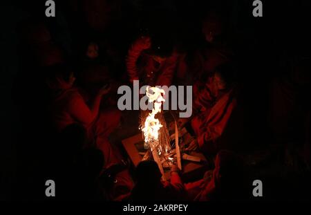 Kathmandu, Nepal. Decimo gen, 2020. Nepalese donne Indù stessi caldo seduti intorno al fuoco dopo aver tenuto un santo bagno nel fiume Salinadi durante Madhav Narayan festival in Sankhu, a nord-est di Kathmandu, Nepal, Venerdì, 10 gennaio 2020. Durante questo festival, celibi donna pregare per un buon marito mentre quelli sposati pregare per la longevità dei loro mariti osservando un mese-lungo digiuno. Credito: Dipen Shrestha che ZUMA/filo/Alamy Live News Foto Stock