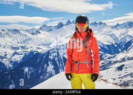 Donna sciatore fiducioso in posa per un ritratto nelle Alpi francesi, dominio sciistico Les Sybelles, Francia, in una giornata di sole con il tempo perfetto di sci. Copia spac Foto Stock