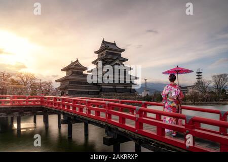 Giovane donna asiatica di indossare il kimono tradizione giapponese vestito dalla visita al Castello Matsumoto durante la fioritura dei ciliegi (Sakura) è uno dei più famosi s Foto Stock