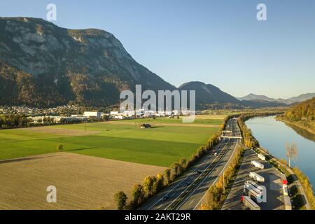 Vista aerea dell'autostrada Interstate road con fast il traffico in movimento vicino al grande fiume nelle Alpi Foto Stock