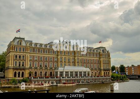 Amsterdam, Olanda, Agosto 2019. L'impressionante facciata dell'hotel. Architettura neoclassica, ha le bandiere dell'Olanda sul tetto: Il tri Foto Stock