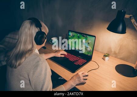 Profilo vista laterale ritratto di lei bella attraente addicted capelli grigi biondi granny giocare rete web virtuale gioco di squadra a industriale Foto Stock