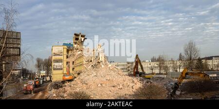 Kraków, Polonia - 18 dicembre 2019: Demolizione di un vecchio edificio di uffici, chiamato Elbud in modo tradizionale, utilizzando escavatori, bulldozer e altri de Foto Stock