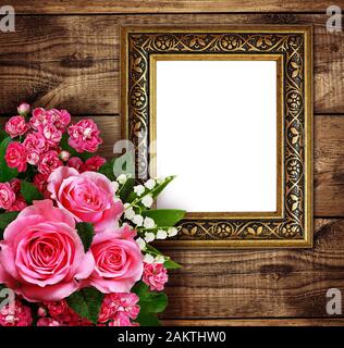 Fiori di colore rosa disposizione e una cornice per foto o testo su legno marrone dello sfondo. Rose, il giglio della valle, biancospino fiori. Foto Stock