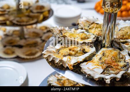 Ostriche fresche aperte su un piatto bianco. Nel ristorante antipasto. Foto Stock