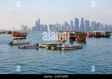 DOHA, QATAR -11 dic 2019- vista giorno del moderno skyline di Doha con un tradizionale dhow imbarcazione in legno nella parte anteriore. La capitale del Qatar include molti superta Foto Stock