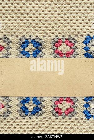 Texture a crochet con motivi quadrati e una scheda di carta per lo sfondo di artigianato Foto Stock