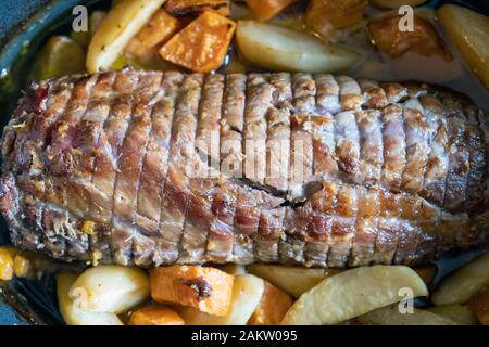 Arrosto di maiale, involtino di pollame con patate servita su un piatto da portata. Un sano panino imbottito come il pranzo per i buongustai. Chiudere fino al di sopra della vista. Foto Stock