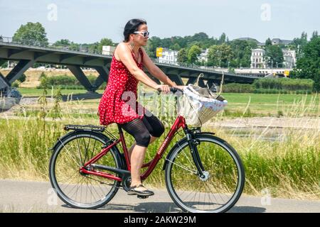 Una donna matura va in bicicletta lungo il fiume Elba Dresda, Germania, stile di vita Dresda, fiume Elba Foto Stock