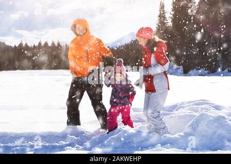 Felice il padre e la madre con la loro figlia a giocare nella neve a Laax Foto Stock