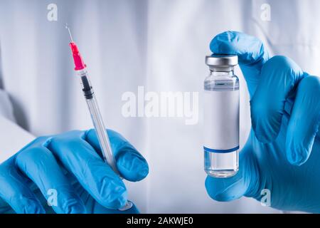 Close-up di un medico che la mano che tiene la siringa di vaccino Foto Stock