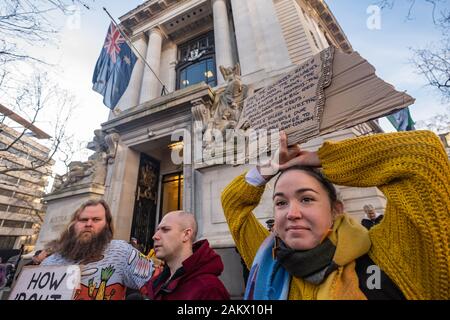 Londra, Regno Unito. Il 10 gennaio 2020. Una donna può contenere fino un poster di fronte Australia casa di estinzione della ribellione protesta in solidarietà con le proteste a Sydney contro il governo su incendi derivanti da decenni di emissioni, centinaia di anni di cattiva gestione di terra poiché invasione e un governo negazione dell'impatto del cambiamento climatico. XR chiamata per un corretto finanziamento dei vigili del fuoco, il sollievo per le comunità, una rapida transizione dai combustibili fossili con supporto per i lavoratori e per la giustizia per la prima nazione europee. Peter Marshall / Alamy Live News Foto Stock