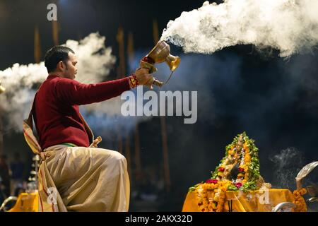 VARANASI, INDIA, 17 gennaio 2019 : sacerdote Indù sventolando incenso cup durante la ganga Aarti cerimonia lungo la riva del fiume Foto Stock