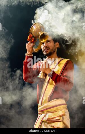 VARANASI, INDIA, 17 gennaio 2019 : Ritratto di sacerdote Indù sventolando incenso cup durante la ganga Aarti cerimonia lungo la riva del fiume Foto Stock