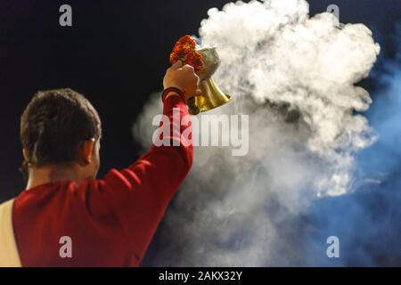 VARANASI, INDIA, 17 gennaio 2019 : sacerdote Indù sventolando incenso cup durante la ganga Aarti cerimonia lungo la riva del fiume Foto Stock