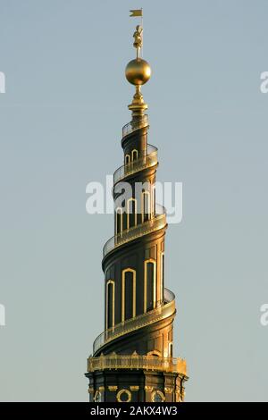 La guglia della Chiesa Del nostro Salvatore a Copenaghen con calda luce del sole del pomeriggio che splende sulla sua guglia elicoidale e sulla scala a chiocciola esterna. Foto Stock