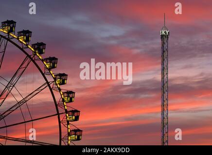 primo piano di cabine con ruote ferris sul fairground contro il drammatico cielo del tramonto Foto Stock