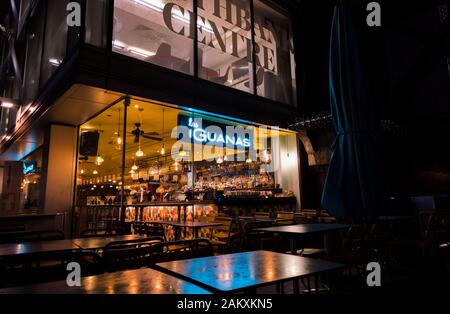 A tarda notte vista dall'esterno del bar chiuso all'interno di Las di iguana ristorante nel centro di Southbank, London SE1 con neon blu accesa nome sign Foto Stock