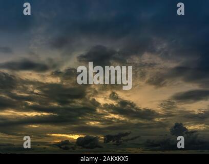Le nuvole riempirono il cielo, oscurando la luce dal sole durante il tramonto. Il cielo al centro è di colore arancione dal sole. La parte inferiore e t Foto Stock