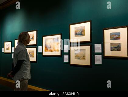 Uomo che guarda le Gallerie nazionali Scozia (NGS) Turner acquerello dipinto mostrato solo in gennaio quando la luce del giorno è debole, Edimburgo, Scozia, Regno Unito Foto Stock