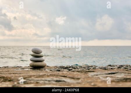 Equilibrio, tranquillità, diverse dimensioni pietre formano una piramide. Foto Stock