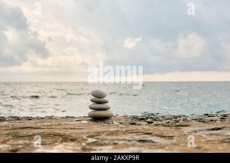 Equilibrio, tranquillità, diverse dimensioni pietre formano una piramide. Foto Stock