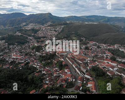 Ampia vista del centro minerario coloniale Ouro Preto a Minas Gerais, Brasile, con montagne circostanti sullo sfondo visto da un alto punto di vista Foto Stock