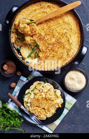 Una porzione di casseruola di patate e fagiolo verde con farcitura croccante servito su un piatto, vista verticale dall'alto, primo piano Foto Stock