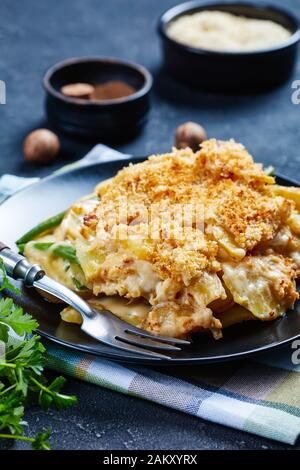 Primo piano di formaggio Potato e casseruola di fagiolo verde con farcitura croccante di pangrattato servito su un piatto, vista orizzontale dall'alto Foto Stock