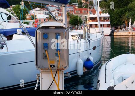 Prese elettriche per la ricarica su imbarcazioni in costa del mare nel Mediterraneo. Stazione di ricarica per imbarcazioni. Telaio orizzontale. Foto Stock