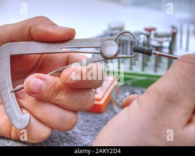 Strumenti dentali sul tavolo nel laboratorio dentale. Ortodontiche, odontotecnico lavora su denti finti. tabella con strumenti dentali. Foto Stock