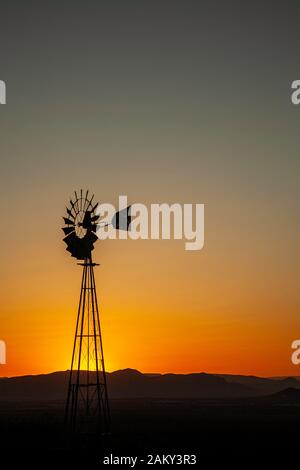 Mulino a vento stagliano contro il cielo arancione, montagne Organ, vicino a Las Cruces, Nuovo Messico USA Foto Stock